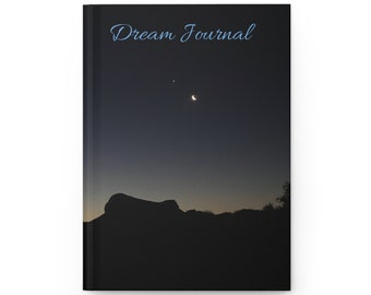 May include: A black and white image of a crescent moon and a star in a dark night sky. The silhouette of a mountain range is in the foreground. The text "Dream Journal" is at the top of the image.