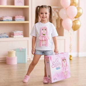Peut inclure: Une jeune fille porte un t-shirt blanc avec un motif de poupée, un short en jean et des baskets roses. Elle tient une valise rose avec une illustration de poupée. Des ballons roses et dorés sont en arrière-plan.