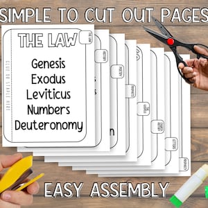 May include: A stack of white paper pages with black text, labeled "THE LAW" and listing Genesis, Exodus, Leviticus, Numbers, and Deuteronomy. The words "SIMPLE TO CUT OUT PAGES" and "EASY ASSEMBLY" are also visible. A pair of scissors and a stapler are in the image.