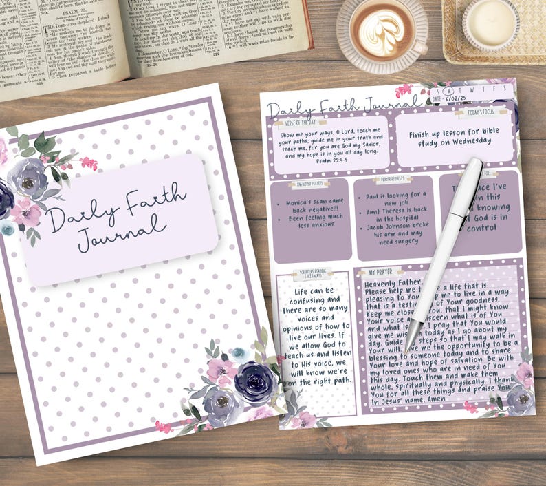Może przedstawiać: Dziennik "Daily Faith Journal" z kwiatowym wzorem w kolorze fioletowym i szarym. Dziennik jest otwarty na stronie z odręcznymi notatkami i długopisem. Okładka ma tytuł "Daily Faith Journal".