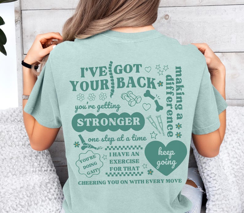 May include: Teal blue t-shirt with a graphic print of a spine, dumbbells, a bone, and a heart. The text on the shirt reads "I've got your back* you're getting stronger one step at a time you're doing gait! I have an exercise for that keep going cheering you on with every move making a difference".
