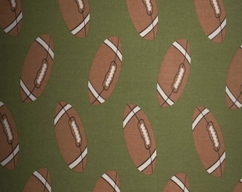 May include: Green fabric with a repeating pattern of brown footballs.