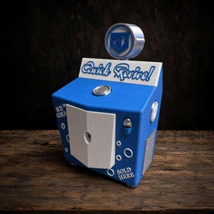 May include: A blue and white vending machine replica featuring the text Quick Revive! on the top panel. The unit includes a central white door, a circular emblem on top, and the phrases ICE COLD and SOLD HERE printed on the front blue surface.