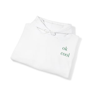 May include: White hooded sweatshirt with the text "ok cool" in green lettering on the front.
