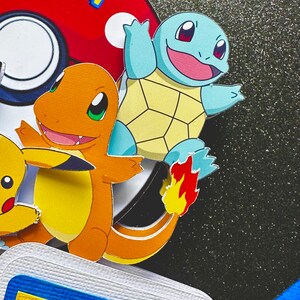 K&ouml;nnte beinhalten: Ein farbenfrohes Papierkunstwerk mit den Pok&eacute;mon-Charakteren Glumanda und Schiggy, einem Pok&eacute;ball und dem Pok&eacute;mon-Logo. Das Design umfasst leuchtende Orange-, Blau-, Gelb- und Rott&ouml;ne mit einem strukturierten Hintergrund.