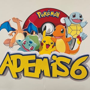 K&ouml;nnte beinhalten: Bunte Pokemon-Tortenaufsatz mit Pikachu, Glumanda und Schiggy. Das Design beinhaltet einen rot-wei&szlig;en Pok&eacute;ball und den Namen "ADEM IS 6" in Gelb und Blau. Ideal f&uuml;r eine Geburtstagsfeier.