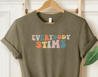 May include: A green t-shirt with the text "EVERYBODY STIMS" in rainbow colors. The text is in a retro font style.