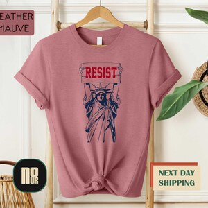 a t - shirt with the statue of liberty holding a sign reading resist next day