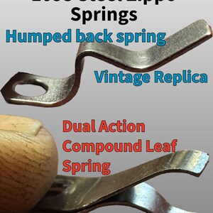 May include: Two metallic lighter springs. The top spring is a 1095 steel humped back spring labeled as a vintage replica. The bottom spring is a dual action compound leaf spring labeled as modern performance. Both are silver-toned metal components.