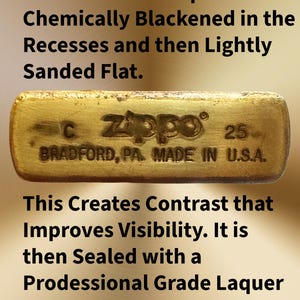 Pode incluir: Close-up da base de um isqueiro Zippo de lat&atilde;o. O texto diz "C Zippo 25 BRADFORD, PA. MADE IN U.S.A." A base &eacute; quimicamente enegrecida e ligeiramente lixada. Selada com laca de grau profissional.