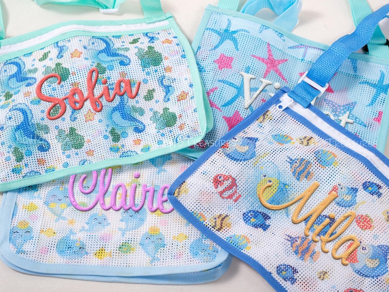 May include: Mesh beach bags with personalized names. The bags feature aquatic-themed patterns with seahorses, fish, and starfish. Each bag has a different name in a cursive font: Sofia, Claire, Mila, and V. The bags have blue and aqua accents.