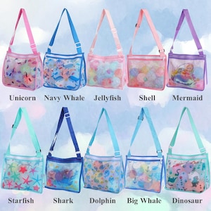 May include: Ten colorful mesh tote bags with adjustable straps. Each bag features a different sea-themed design, including unicorns, whales, jellyfish, shells, mermaids, starfish, sharks, dolphins, and dinosaurs. The bags have matching colored straps and text labels.