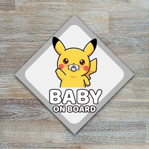 Op de afbeelding: Een ruitvormige autosticker met een gele stripfiguur die een hand omhoog houdt en een fopspeen draagt. De tekst "BABY ON BOARD" is in vette, witte letters eronder gedrukt.
