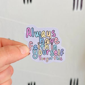 May include: A pastel-colored sticker with the words "Always have faith in yourself, You got this" in a whimsical font. The sticker has a light purple background and colorful outlines.
