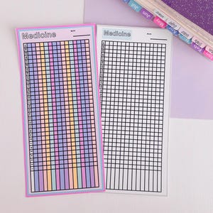 May include: Two rectangular medicine tracker sheets. The left sheet features a pink border and columns with pastel purple, yellow, and blue grid cells numbered 1 through 31. The right sheet has a white border with black grid lines.