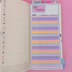 Może przedstawiać: Strona planera z sekcją "Bill Tracker". Tracker ma siatkę z pastelowymi rzędami do śledzenia rachunk&oacute;w od stycznia do grudnia. Strona jest otwarta na kalendarz z datami i notatkami.