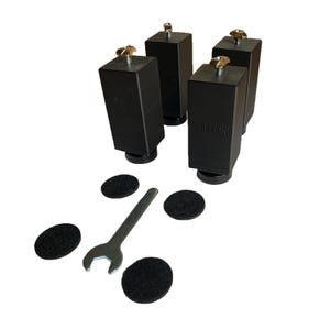 Op de afbeelding: Vier zwarte verstelbare meubelleggers met een gouden schroef aan de bovenkant, een schroevendraaier en vijf zwarte viltpads. De leggers hebben de tekst "XL Racing" erop gedrukt.