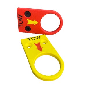May include: Two flat, rectangular tow hook markers with circular ends. One is red with a yellow arrow and black text reading TOW, featuring two black bolts. The other is yellow with a red arrow and black text reading TOW, featuring two mounting holes.