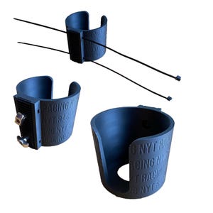 May include: Three dark gray cylindrical mounts with open sides, featuring the embossed text "NYT RACING". One mount includes two long black zip ties, another has two silver metal bolts with wing nuts, and the third has a circular cutout at the base.