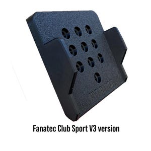 Può includere: Dispositivo rettangolare nero, strutturato, con nove fori circolari e due supporti laterali. Il testo "Fanatec Club Sport V3 version" è stampato in basso. Il dispositivo sembra essere un componente per un simulatore di corse.