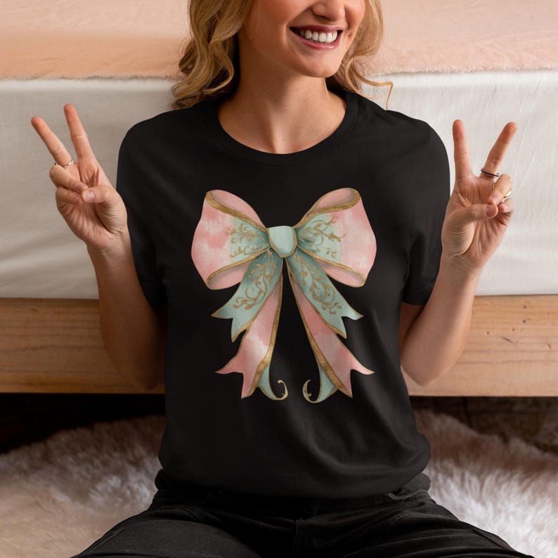 May include: A black t-shirt with a large pink and green bow with gold accents.