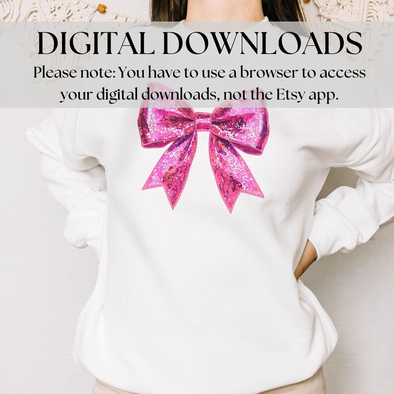 May include: White sweatshirt featuring a large, sparkly pink bow graphic. The text "DIGITAL DOWNLOADS" is at the top, with a note about accessing downloads via a browser. The bow has a glittery texture and is centered on the shirt.