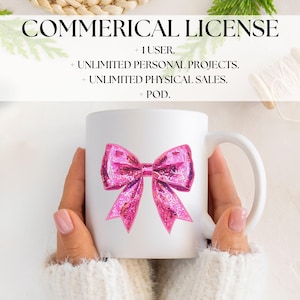 May include: White ceramic mug featuring a large, glittery pink bow design. The mug has a curved handle and is held by a person wearing a white sweater. Text at the top reads "COMMERICAL LICENSE".