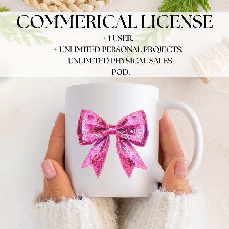 May include: White ceramic mug featuring a large, glittery pink bow design. The mug has a curved handle and is held by a person wearing a white sweater. Text at the top reads "COMMERICAL LICENSE".