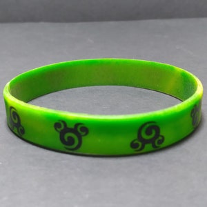 Op de afbeelding: Groen siliconen armband met zwarte swirl-ontwerpen.