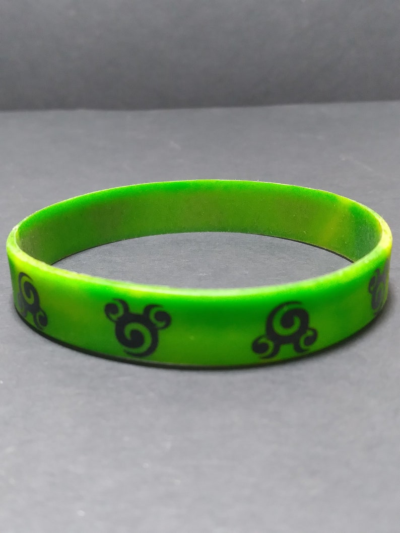 Op de afbeelding: Groen siliconen armband met zwarte swirl-ontwerpen.