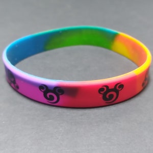 Op de afbeelding: Een veelkleurig siliconen armband met een zwart Mickey Mouse silhouet ontwerp.