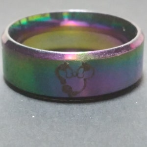 May include: A rainbow iridescent stainless steel ring with a Mickey Mouse silhouette engraved on the band.
