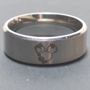 May include: A silver ring with a Mickey Mouse head engraved on the band.
