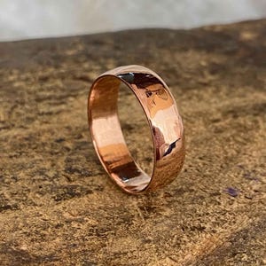 May include: A hammered copper wedding band with a rounded profile.
