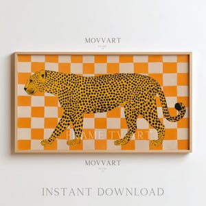 Puede incluir: Una impresión enmarcada que presenta un leopardo amarillo estilizado con manchas negras, sobre un fondo a cuadros naranja y blanco. La obra de arte está en un marco de madera e incluye el texto "MOVART" y "FRAME TV ART".