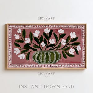 May include: A framed floral painting featuring white flowers and green leaves in a striped green vase. The background is a muted red-pink color. The frame is a light brown color. The text "MOVART" and "INSTANT DOWNLOAD" are visible.