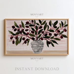 May include: A framed print featuring an olive branch arrangement in a striped vase. The artwork displays green leaves and dark purple olives against a pink and beige background. The text "MOVART" and "INSTANT DOWNLOAD" are visible.