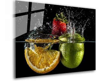 May include: A red strawberry, a green apple, and a slice of orange are submerged in water. Water droplets are splashing around the fruit. The background is black.