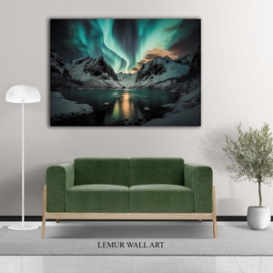 K&ouml;nnte beinhalten: Ein gr&uuml;nes Sofa steht vor einer Wand mit einem gro&szlig;en Leinwanddruck eines Gebirges mit einer gr&uuml;n-blauen Aurora Borealis, die sich in einem See vor den Bergen spiegelt.