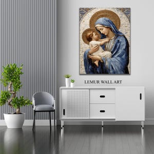 May include: A mosaic wall art print depicting a mother and child. The mother is wearing a blue robe and holding the child in her arms. The child is wearing a white robe and looking up at the mother. The background is a mosaic of gold and white tiles.