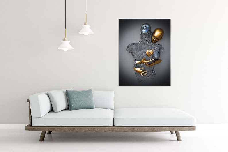 May include: Abstract metal sculpture of two figures embracing, one silver and one gold, with a gold heart in the center. The sculpture is mounted on a dark gray background.