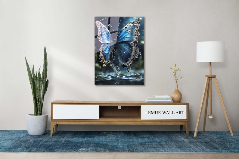 May include: A blue butterfly with gold accents is perched on a water droplet. The butterfly is surrounded by water droplets and a blurred background.