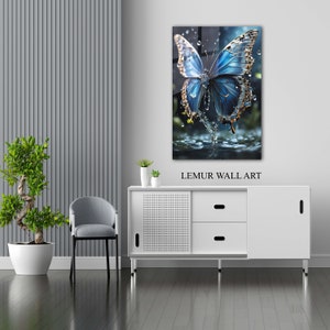 May include: A blue butterfly with iridescent wings emerges from a pool of water. The butterfly is surrounded by water droplets. The image is a glass wall art piece with the text "LEMUR WALL ART" below the image.