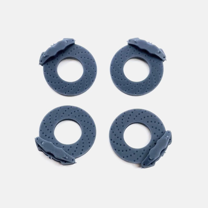May include: Four blue brake rotors with brake calipers attached. The rotors are made of a textured material and have a circular shape. The calipers are attached to the rotors and have a curved shape.