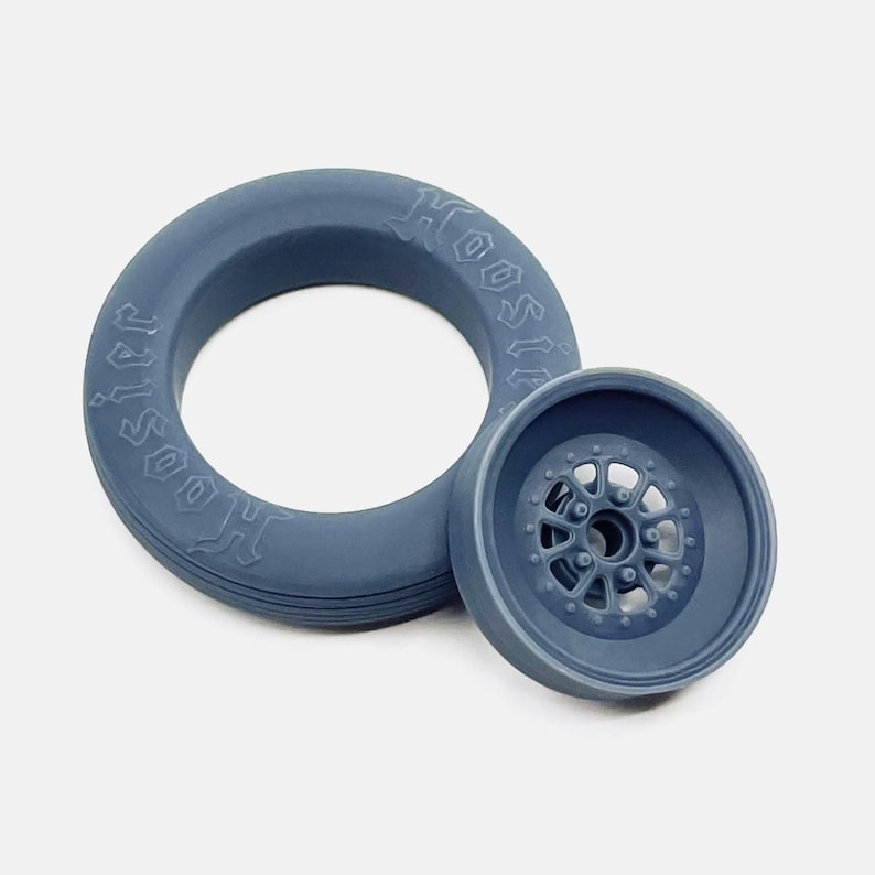 May include: A blue rubber tire with the word "Hoosier" embossed on the side, and a blue plastic wheel with a detailed spoke design.