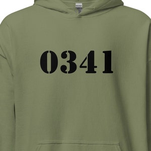 Könnte beinhalten: Ein grüner Kapuzenpullover mit der Nummer "0341" in Schwarz auf der Vorderseite.