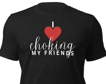 May include: Black t-shirt with the text "I ❤️ choking MY FRIENDS" in white script and a red heart. The shirt is made of a soft material and has a crew neck.