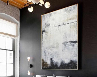 May include: Abstract art piece with a gold frame. The artwork features a textured, layered design in shades of white, black, and brown. The painting hangs above a bed with patterned pillows, creating a modern interior design.