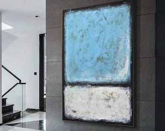 May include: Abstract painting featuring a blue and white colour scheme. The top half of the painting is a light blue with a textured finish. The bottom half is white with a more subtle texture. The painting is framed in black.
