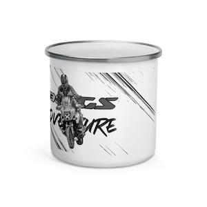May include: White enamel camping mug with a black and white graphic of a person riding a motorcycle. The text "B.C.S. Adventure" is printed on the mug.
